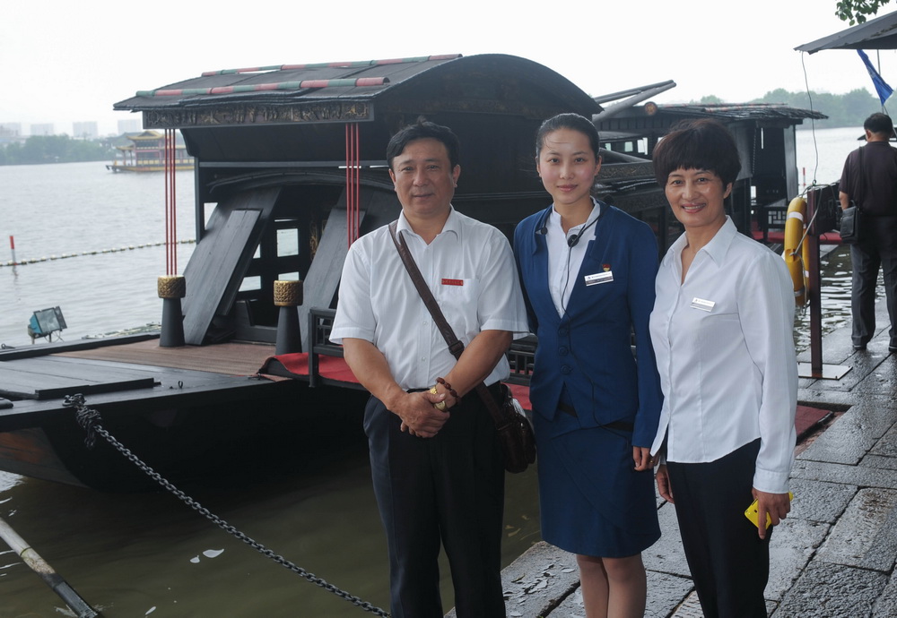 張一（中）和父親張新志、母親徐金巧在紅船邊合影（2012年6月28日攝）。新華社記者 韓傳號 攝