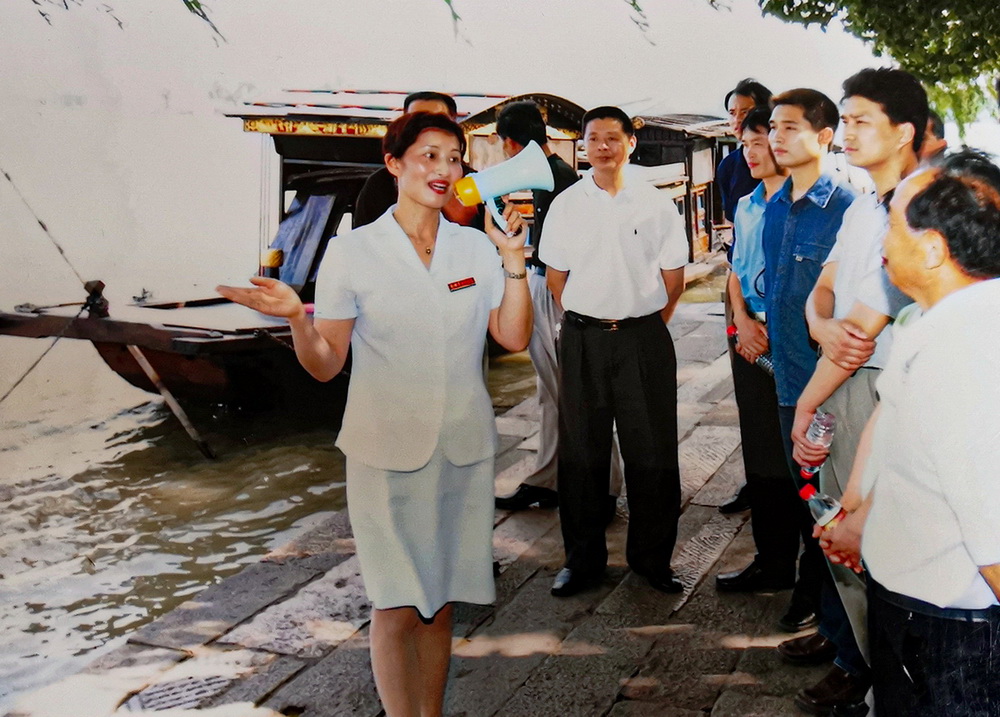 21世紀初，徐金巧（前左）在紅船前為游客進行講解。新華社發（受訪者供圖）