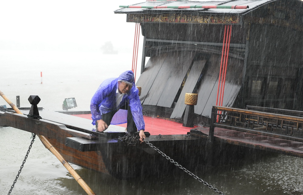 張新志在暴雨天氣中拽緊纜索，保護紅船免受狂風損害（資料照片）。新華社發（受訪者供圖）