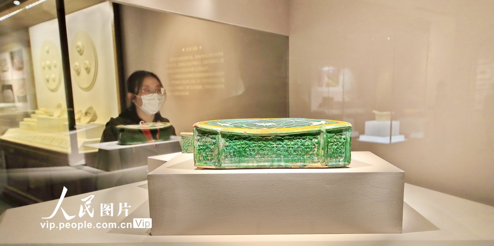 觀眾參觀“龍門遺粹——山西河津窯考古成果展”展出的三彩剔花開光牧歸圖八角枕。