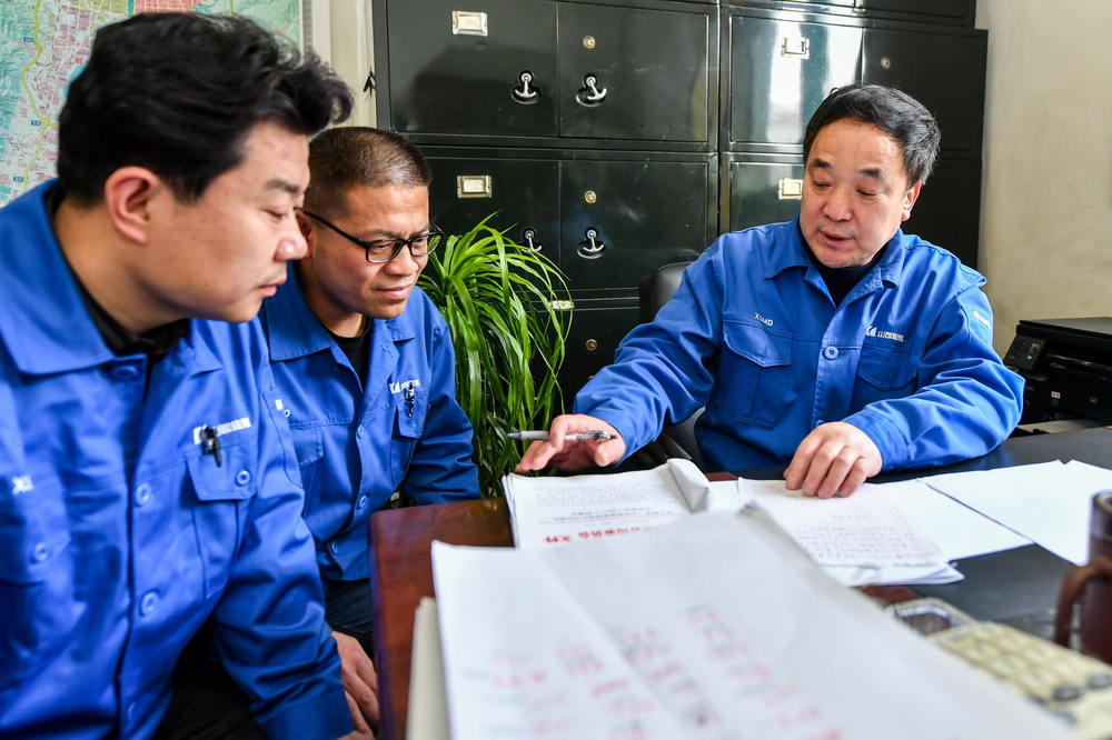 張海（右）為職工講解轉崗政策（3月11日攝）。新華社記者 曹陽 攝