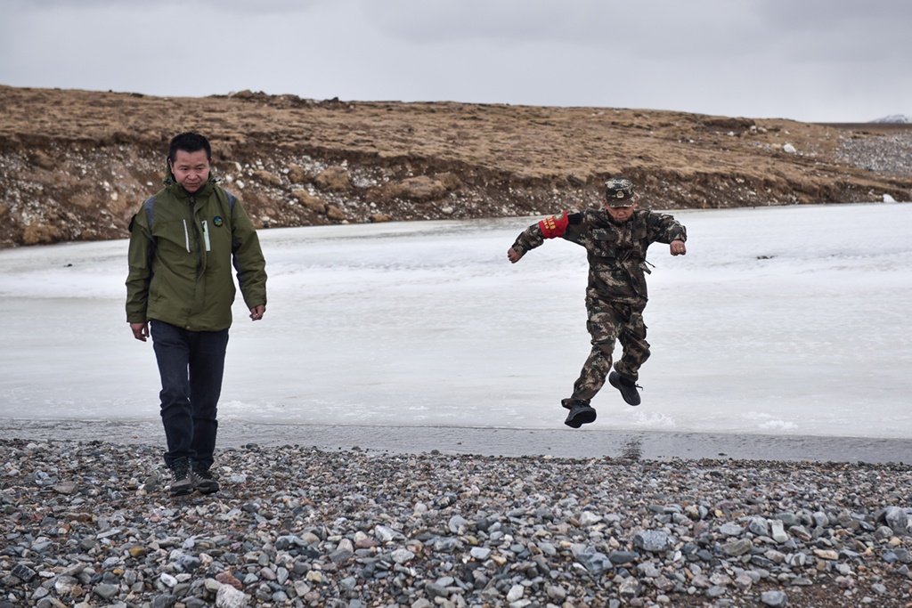 4月23日，祁連山國家公園沙龍灘管護站生態管護員羅藏次成（右）在巡護途中跳過水面。新華社記者 吳剛 攝