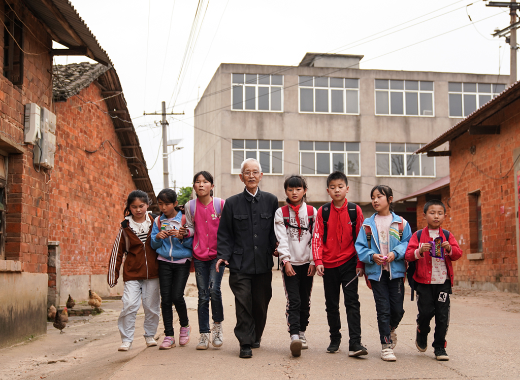 繆延相（左四）和放學的孩子們一起前往校外輔導站（4月20日攝）。
