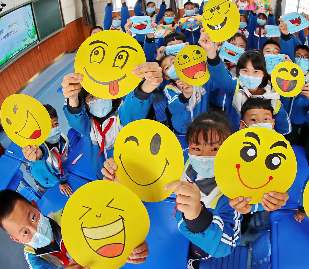 5月7日，秦皇島市海港區東港鎮第一小學的學生在“彩繪笑臉 放飛心情”活動上展示繪制的笑臉。新華社發（曹建雄 攝）