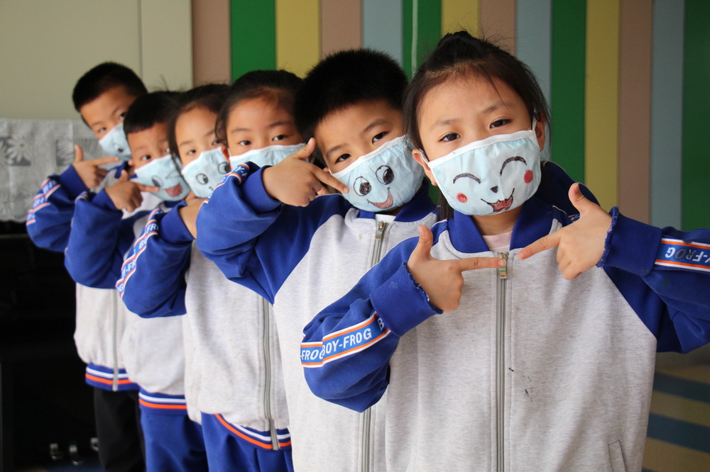 5月7日，山東省濱州市高新區實驗幼兒園的小朋友們在迎接“世界微笑日”活動上展示制作的“笑臉口罩”作品。新華社發（初寶瑞 攝）