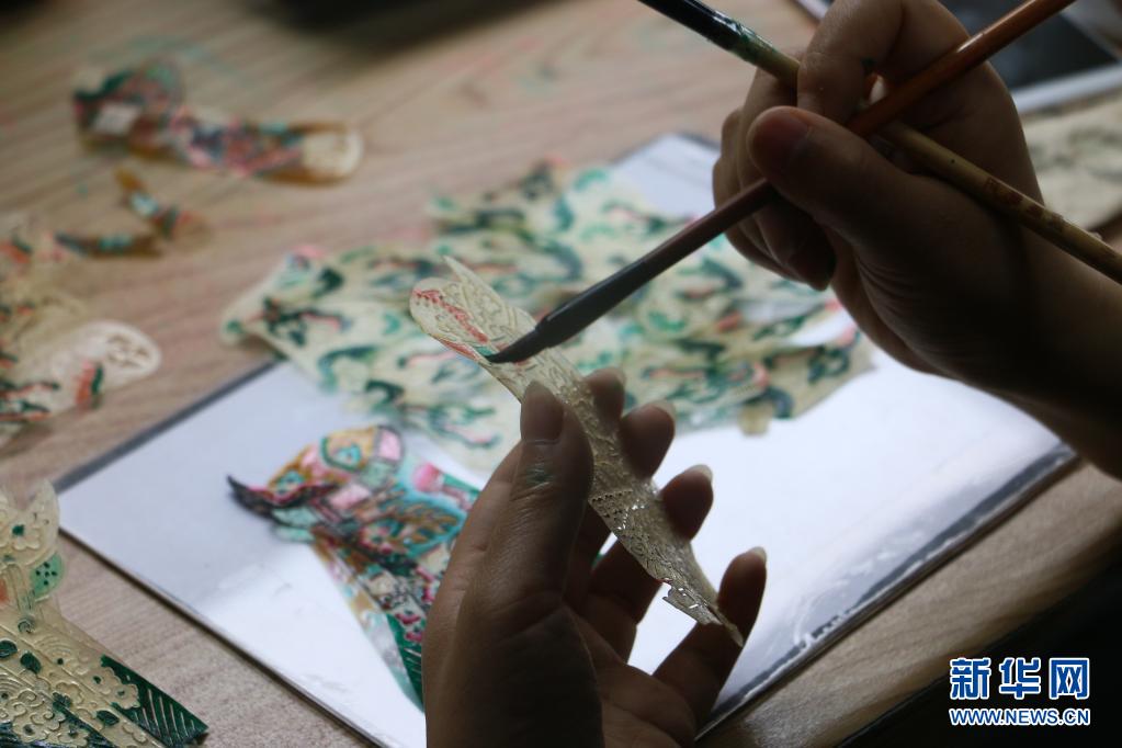 5月8日，工作人员在陕西省渭南市华州区少华山国际皮影博览园为皮影上色。新华社发（李保娟 摄）