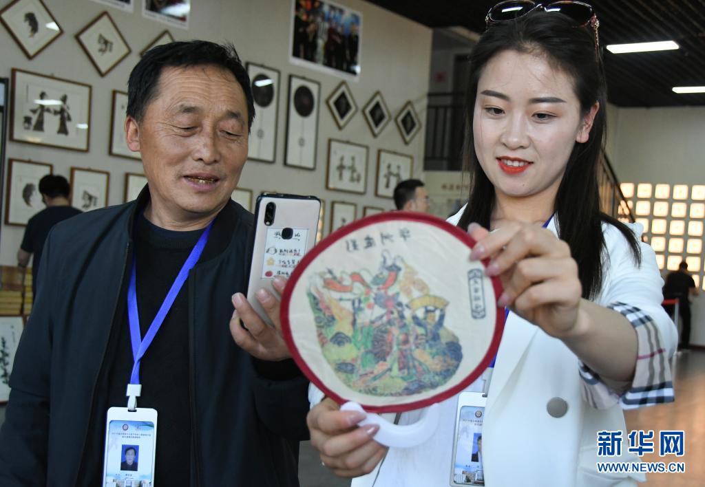 5月8日，游客（右）在陕西省渭南市华州区少华山国际皮影博览园挑选皮影文创产品。新华社记者 王泽 摄