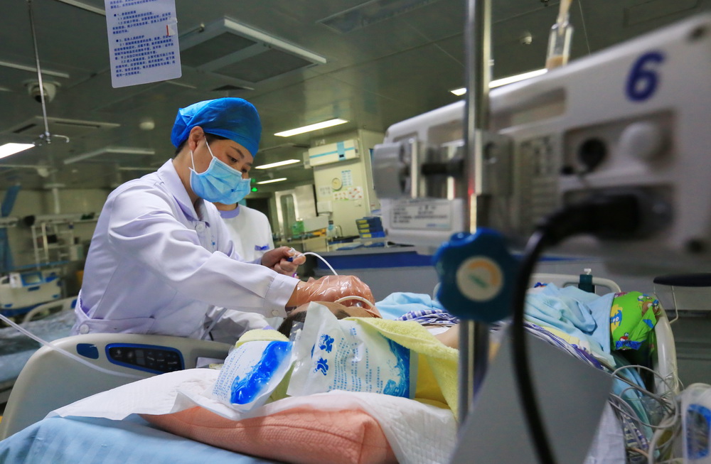 5月11日，在贵州省毕节市第一人民医院重症医学科病房，一名护士对患者进行护理。新华社发（王纯亮摄）
