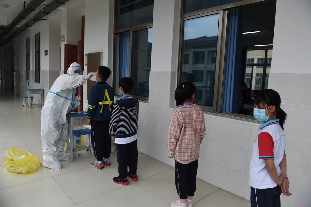5月17日，在六安市清水河學校第二小學，檢測人員為學生做核酸檢測。