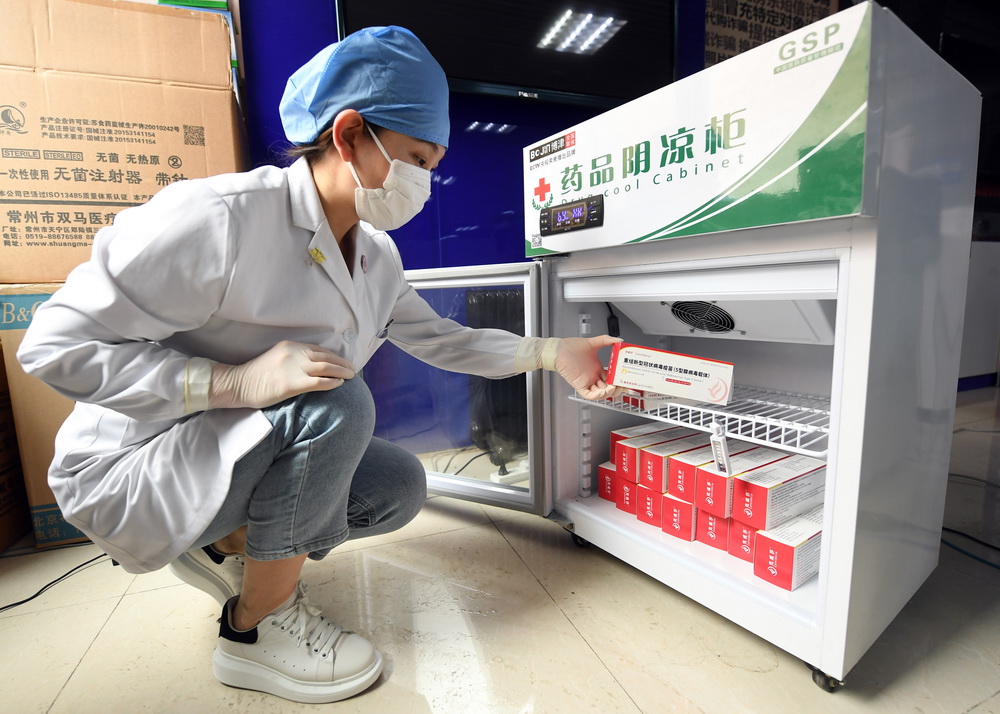 5月20日，在北京市海淀区花园路街道新冠疫苗临时接种点，医护人员从药品阴凉柜中取出一剂次新冠疫苗。
