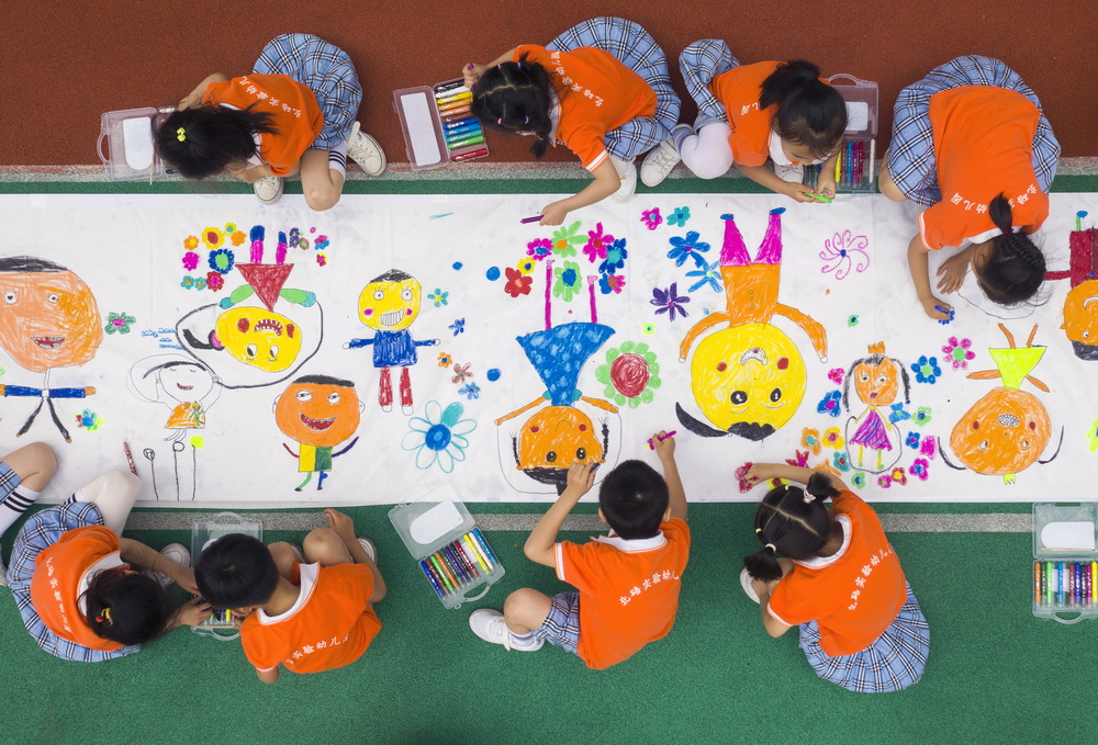 5月26日，重慶市北碚區實驗幼兒園的孩子們在長卷上繪畫（無人機照片）。