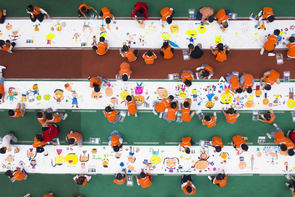 5月26日，重慶市北碚區實驗幼兒園的孩子們在長卷上繪畫（無人機照片）。
