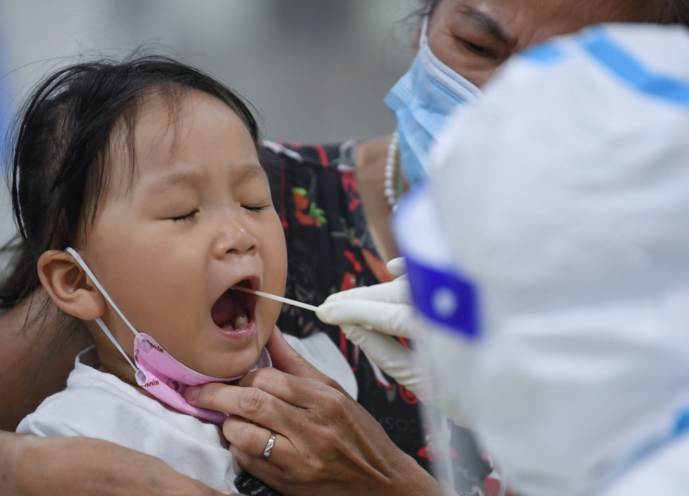 在廣州荔灣體育館核酸檢測點，小朋友接受核酸檢測採樣（5月26日攝）。