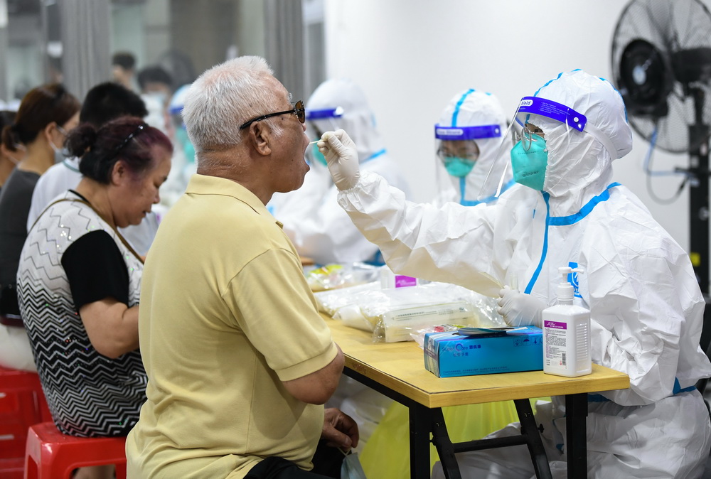 在廣州荔灣體育館核酸檢測點，市民進行核酸檢測採樣（5月26日攝）。