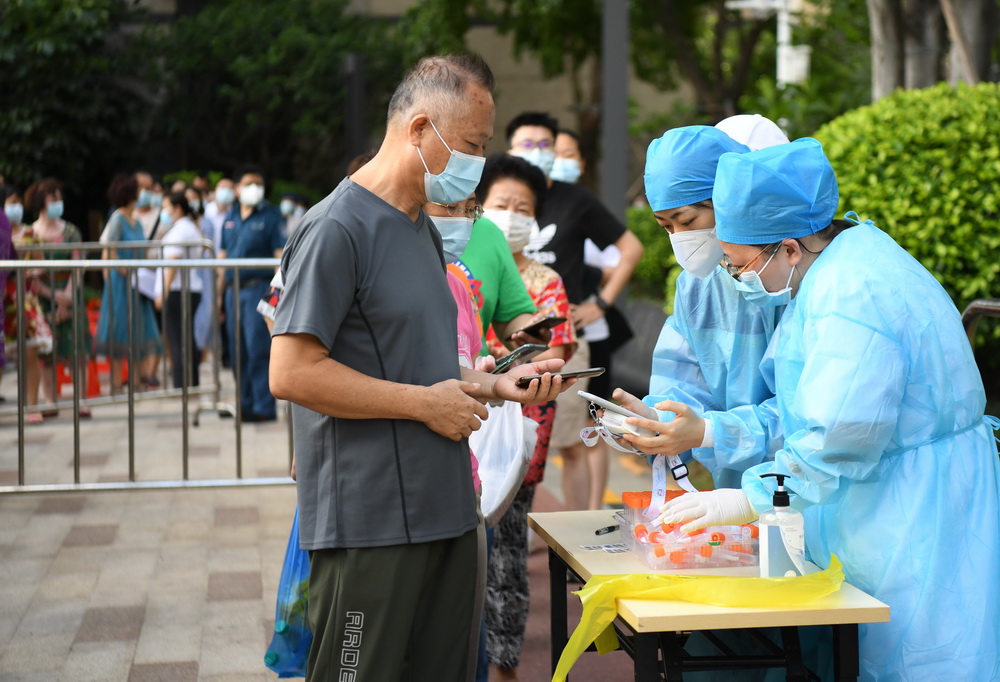 5月27日，在廣州荔灣區中海錦佳華庭小區核酸檢測點，醫務人員核對前來進行核酸檢測的市民的信息。