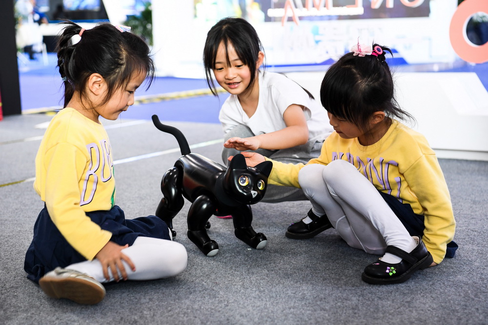 5月27日，孩子們在“數博會”上與一款AI仿生機器貓互動。新華社記者 楊文斌 攝