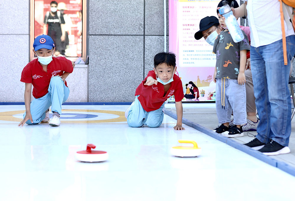 5月29日，小朋友在中国儿童中心的活动上体验旱地冰壶。
