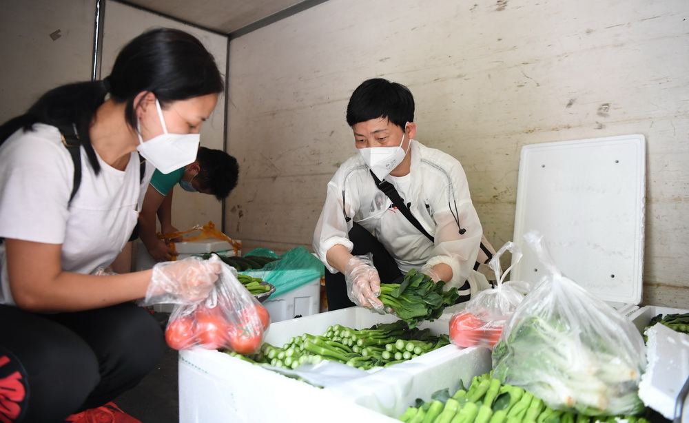 5月30日，在廣鋼新城廣州友誼商店移動服務點，工作人員整理售賣的蔬菜。