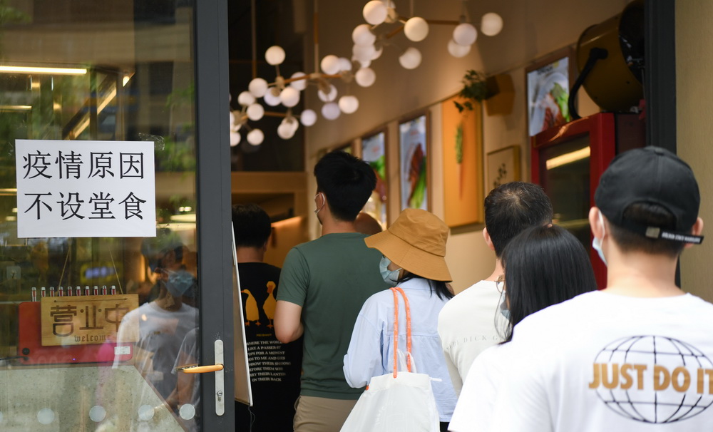 5月30日，在廣州荔灣區白鶴洞街道廣鋼新城一小區門店，市民排隊購買燒味。