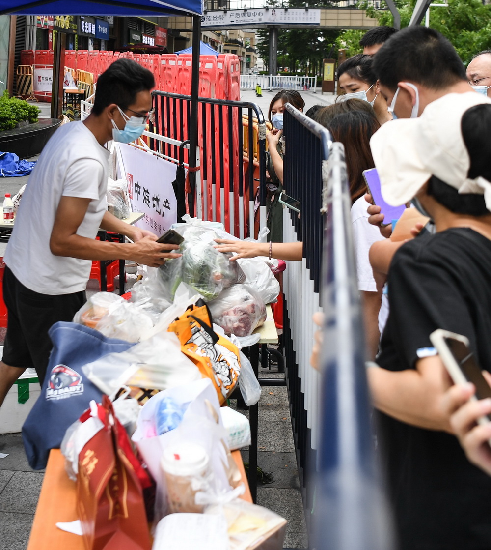 5月30日，在廣鋼新城封閉路口附近的網購貨物線下集中配送點，市民領取線上購買的物品。