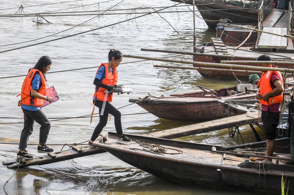 袁婷（左二）與同事一起登上漁船准備開展野外漁業資源調查（5月29日攝）。