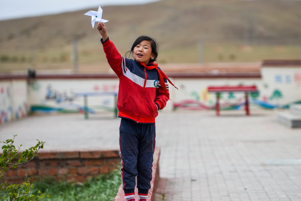 5月28日，大庫倫鄉小學的學生在課間玩紙風車。