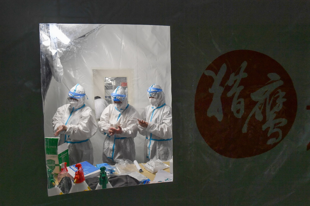 檢測人員在進入氣膜方艙實驗室核酸檢測樣品處理區之前穿戴防護設備（6月1日攝）。