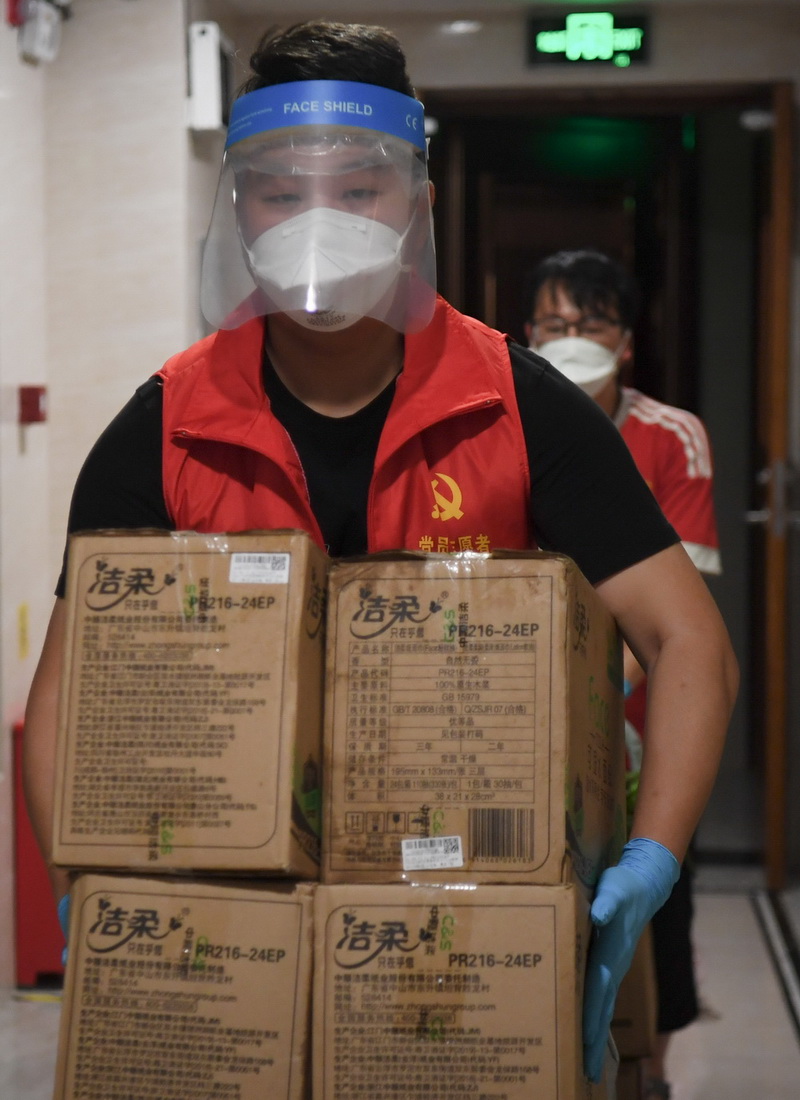 6月1日，在廣州荔灣區白鶴洞街道一小區，一位配送志願者搬運網購物品。