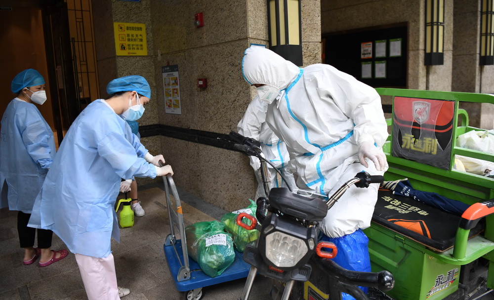 6月2日，在廣州荔灣區白鶴洞街道一小區，物業人員將業主網購的物品運送至樓棟門口，再由配送志願者送至各住戶門口。