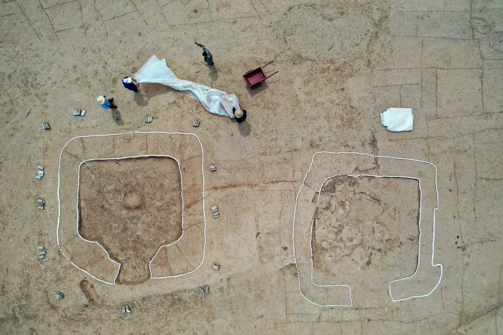 在陶寺遺址宮城內的大型夯土建筑基址上，工作人員用薄膜覆蓋房址地面進行保護（6月3日攝，無人機照片）。