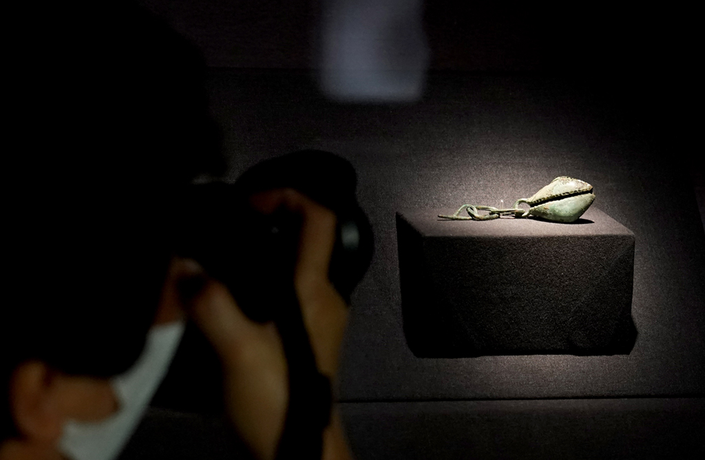 6月7日，一名媒體記者在上海奉賢博物館展廳拍攝四川廣漢三星堆博物館藏文物“銅扇貝形挂飾”。