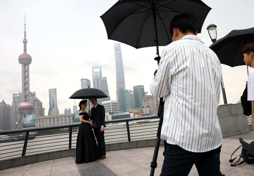 6月10日，游客在雨中的上海外灘拍攝藝術照片。