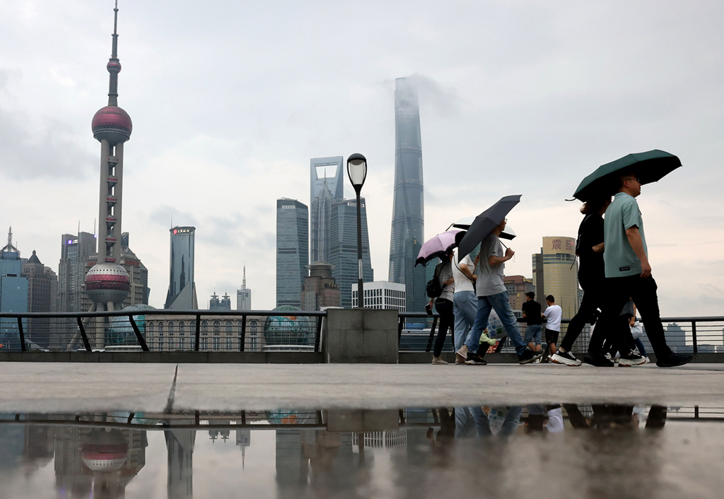 6月10日，游客在雨中游覽上海外灘。
