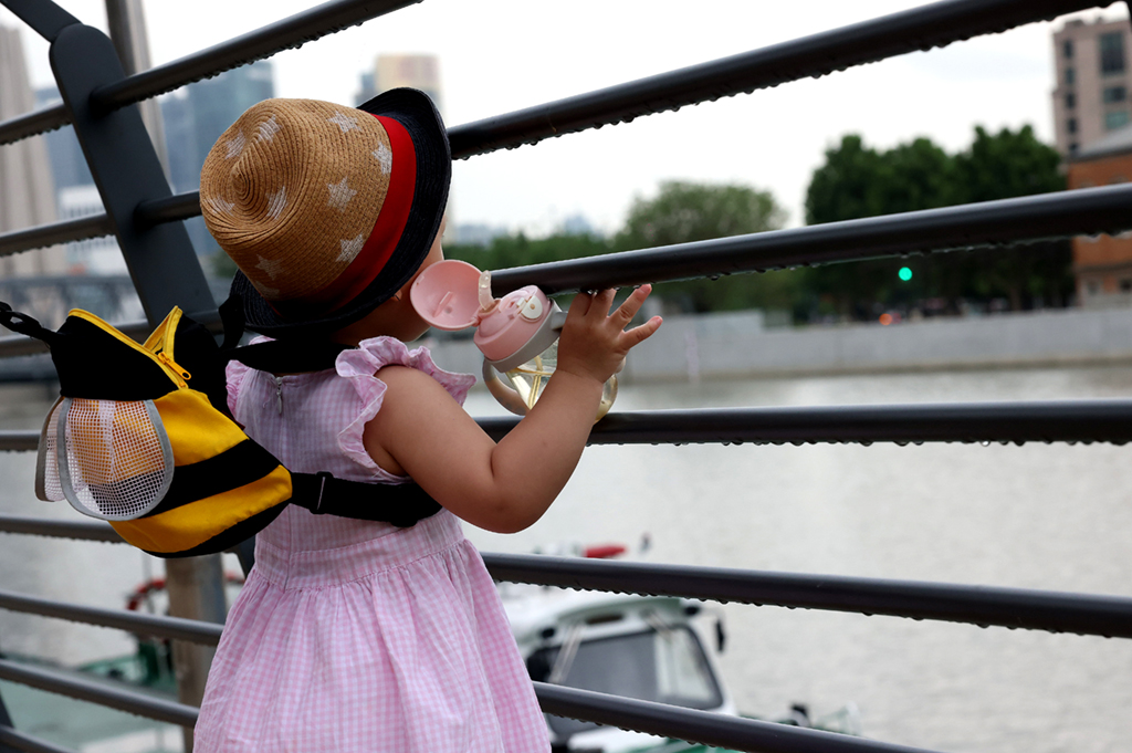 6月10日，一名小朋友在雨后的上海蘇州河乍浦路橋附近玩耍。