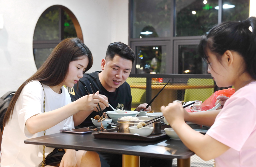 6月10日，游客在福建三明市沙縣區一家小吃店品嘗特色小吃。