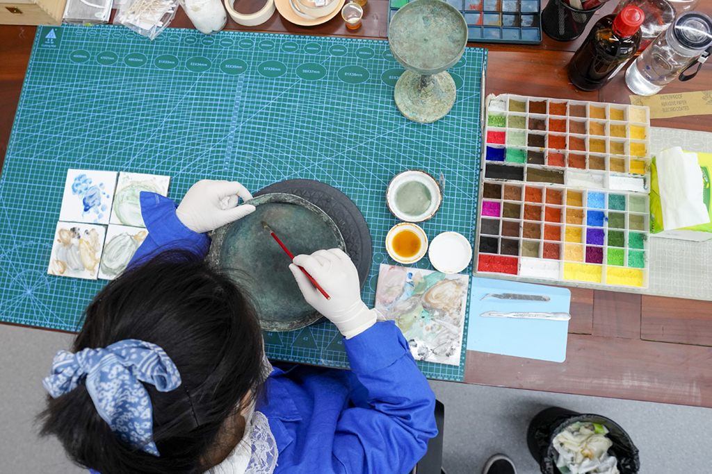 6月9日，在三峽文物科技保護基地的文物修復室內，文物修復師崔玉婷為文物修補部分做舊，以保持文物展品外觀統一協調。