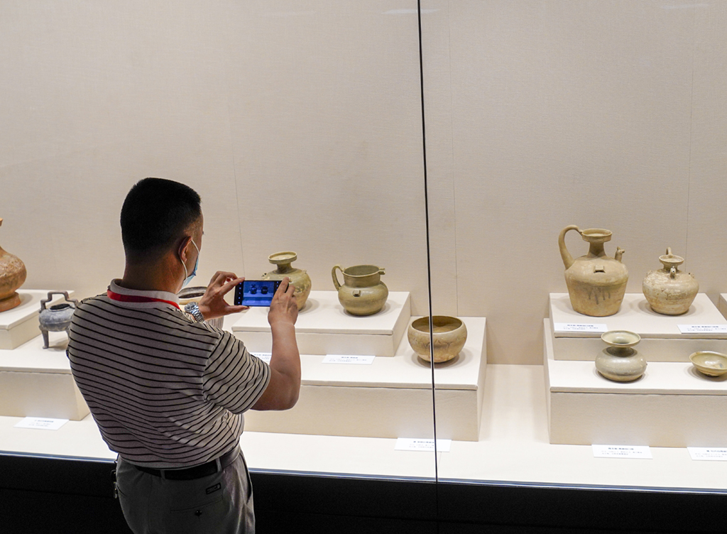 6月11日，在三峽文物科技保護基地的《世紀工程國家行動——三峽文物保護成果展》展廳內，參觀者拍攝三峽地區發掘出來的珍貴文物。