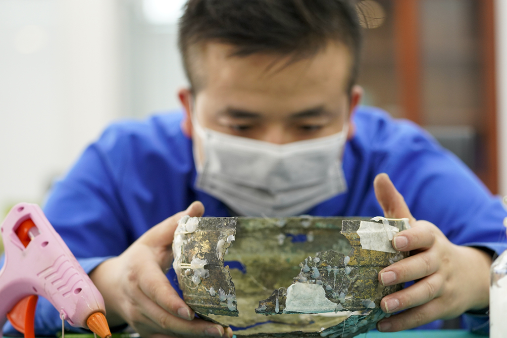 6月9日，在三峽文物科技保護基地的文物修復室內，文物修復師趙曉宇在修復一件漢代的青銅器。