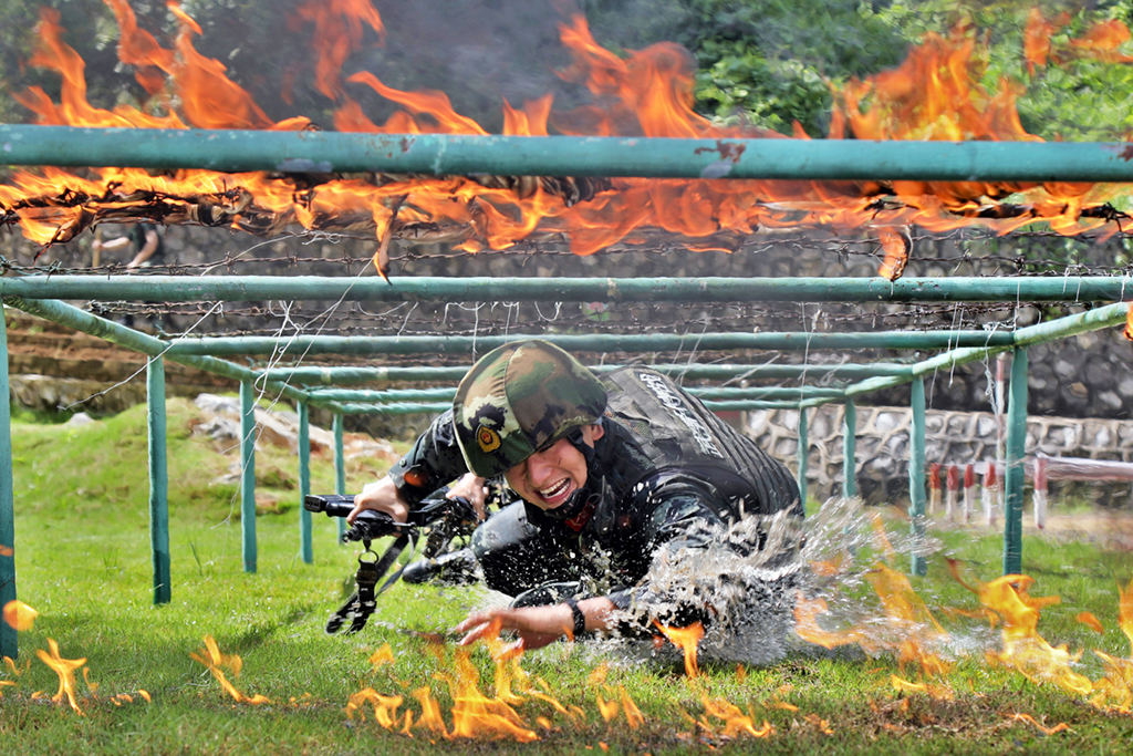 武警廣西總隊崇左支隊執勤大隊憑祥中隊官兵進行穿越火障訓練（2019年8月6日攝）。新華社發（余海洋 攝）