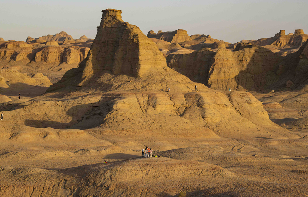 游客在新疆克拉瑪依烏爾禾世界魔鬼城景區內拍照游玩（6月21日攝）。新華社記者 胡虎虎 攝
