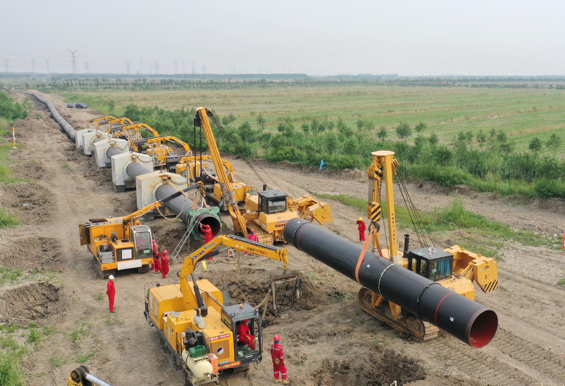 6月24日，工人在唐山市豐南區王蘭庄鎮境內的曹妃甸區新天LNG接收站外輸管線項目(曹妃甸-寶坻段)建設工地施工（無人機照片）。