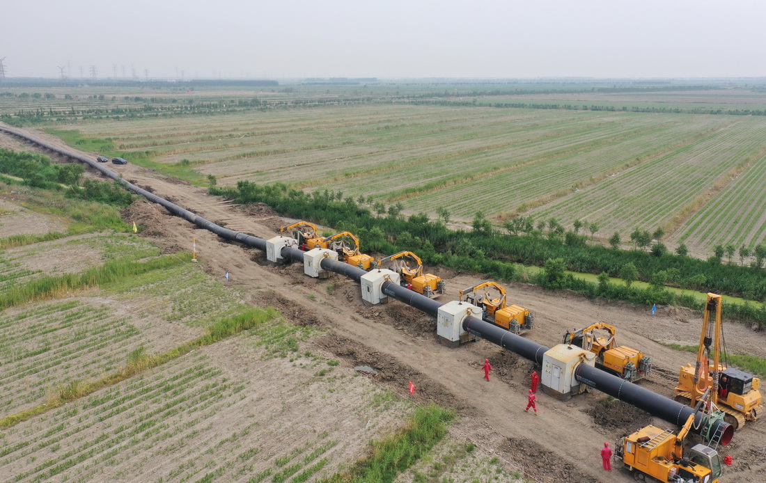 6月24日，工人在唐山市豐南區王蘭庄鎮境內的曹妃甸區新天LNG接收站外輸管線項目(曹妃甸-寶坻段)建設工地施工（無人機照片）。