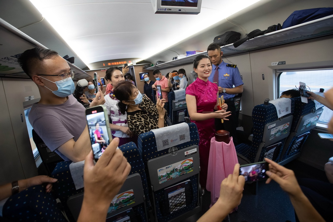 6月28日，在D1758次列車上，演員為乘客表演自貢市特色文化節目四川清音《千年鹽都等你來》。新華社記者 江宏景 攝