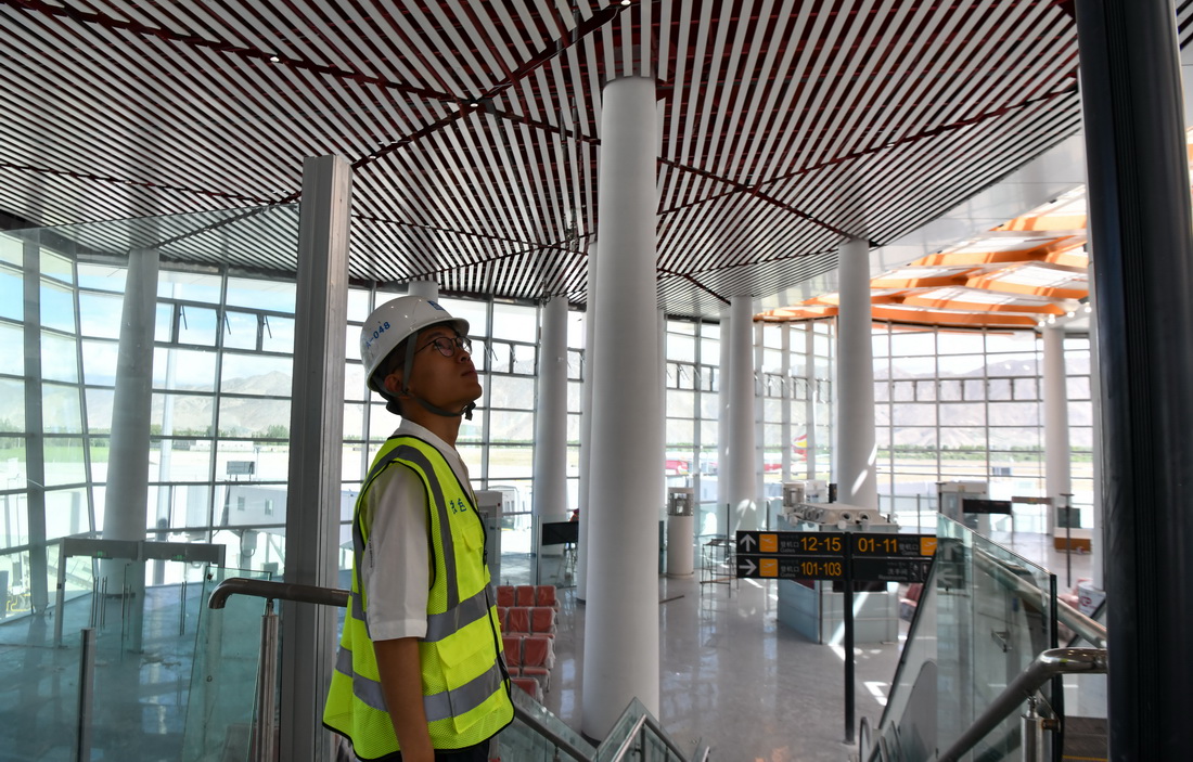 6月30日，施工人員在拉薩貢嘎國際機場T3航站樓內查看工程細節。