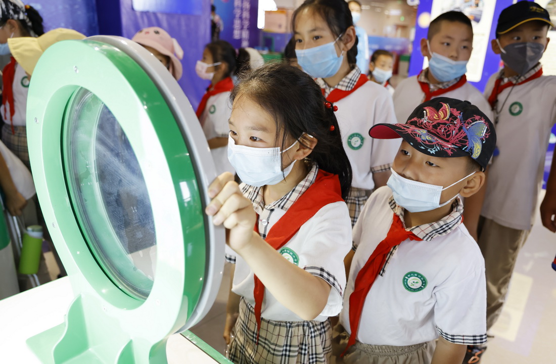 6月29日，宁夏银川市贺兰县回民小学学生在“流动科技馆”体验科技互动装置。