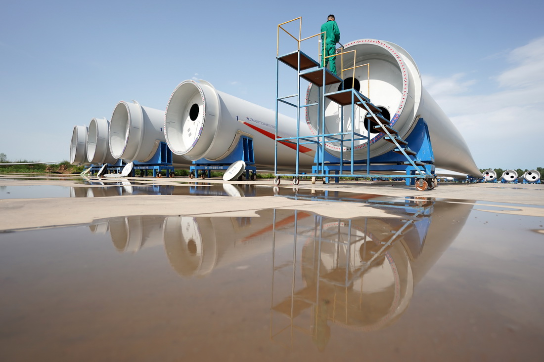6月30日，河北省威县一家风电机组叶片制造企业工人在调试大型风电机组叶片螺孔。
