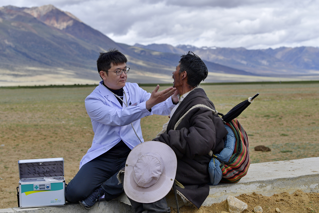 王克明（左）在西藏當雄縣格達鄉格達村牧場為牧民義診（6月19日攝）。新華社記者 張汝鋒 攝