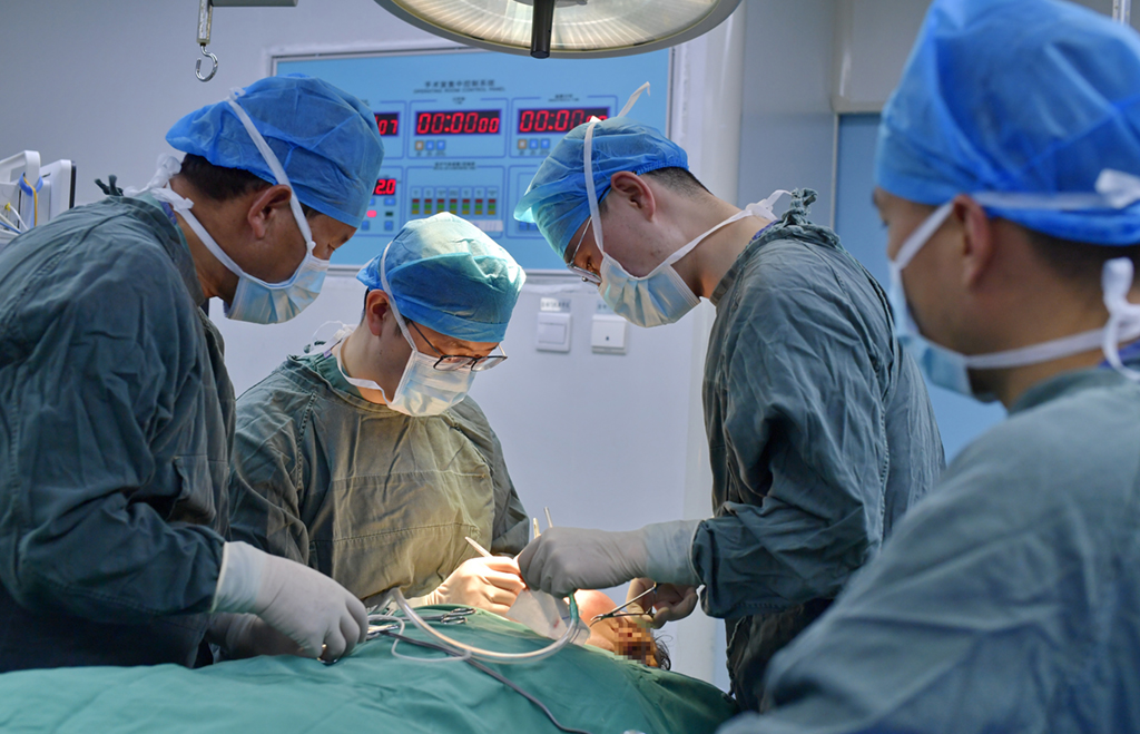 在西藏自治區人民醫院手術室，王克明（左二）和同事為面部畸形患者做手術（5月11日攝）。新華社記者 張汝鋒 攝 (2)