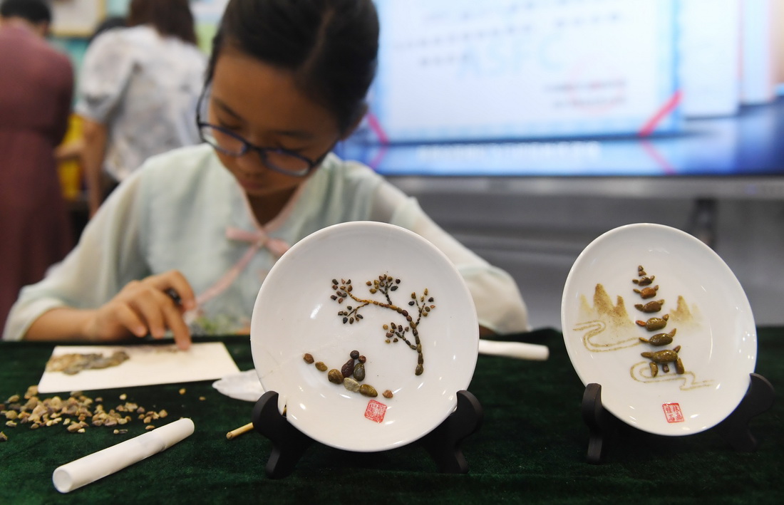 7月10日，在南宁国际会展中心，来自广西桂林市平山小学的学生在展示石画技艺。
