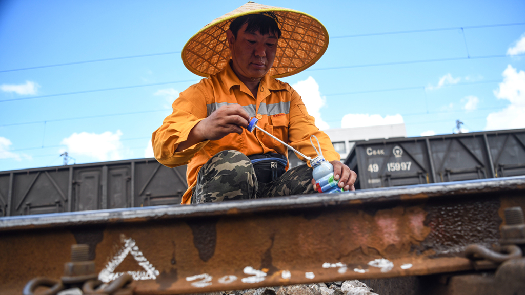 在柳州南编组站，柳州工务段的探伤工用油漆在钢轨轨底标注轻伤检查情况（7月9日摄）。